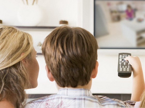 Family in living room with remote control and flat screen televi