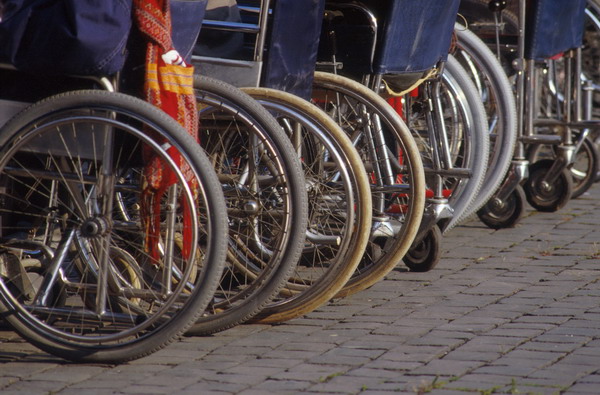 CARROZZINE DI DISABILI ALLINEATE IN UNA MANIFESTAZIONE PUBBLICA