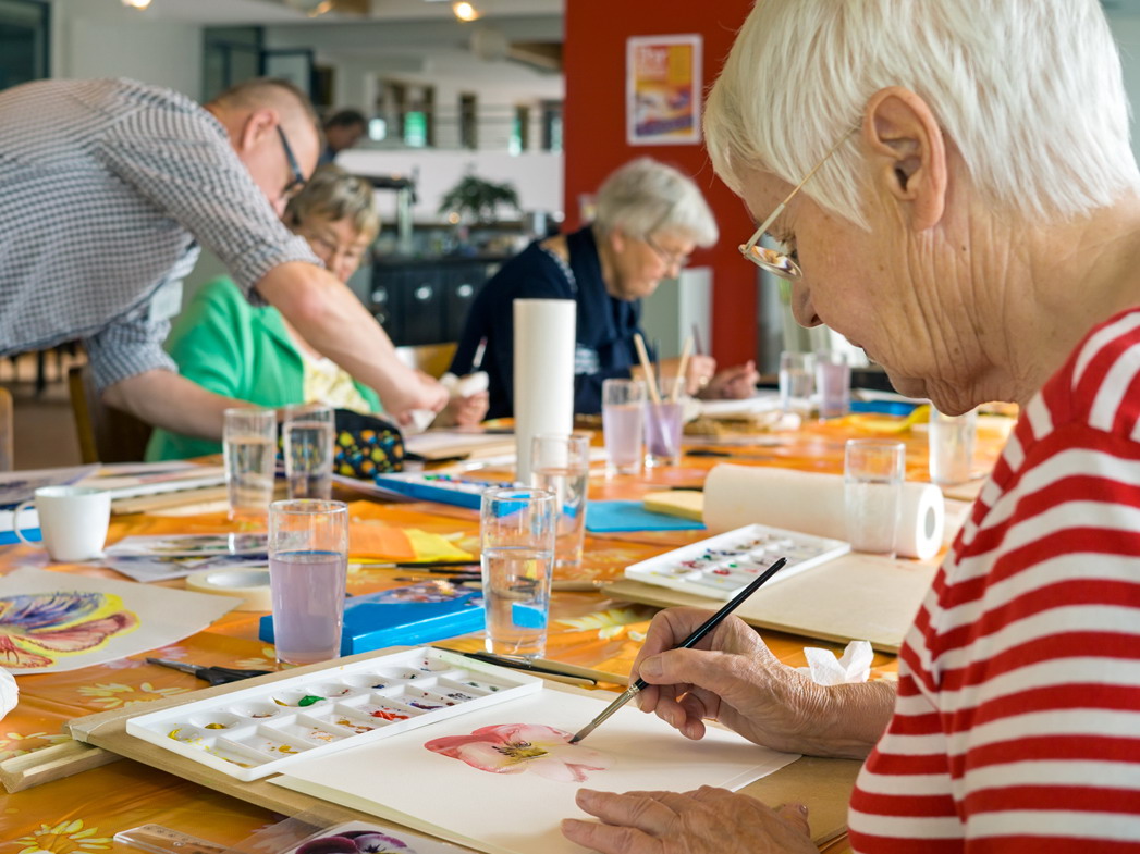 Woman working on watercolor painting.