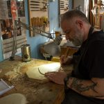 Un detenuto al lavoro su un violino