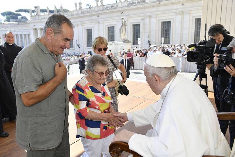 Papa Francesco saluta due anziani